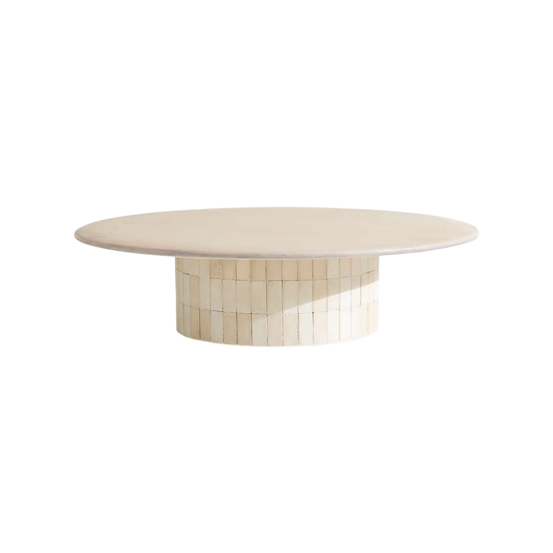 Large round outdoor coffee table made of beige stone and mineral-washed plaster