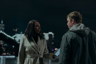 amanda warren as catherine and gabriel basso as peter sutherland having a meeting by the new york city waterfront in the night agent season 2