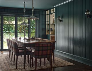 A dining room with dark wooden floor and dark blue walls