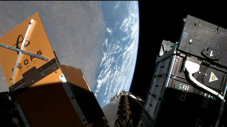 various space probe cubesats are attached to a payload adapter in orbit of Earth.