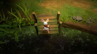 A cute mouse wearing a red sash stands on a short jetty at the edge of a pond.