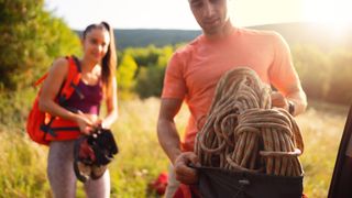 how to store climbing rope: climber packing rope away