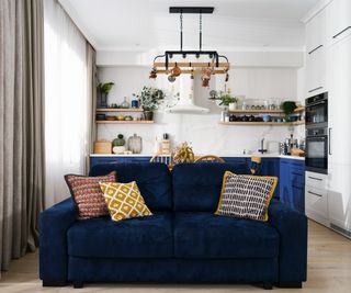 Light cozy kitchen with blue and white facades and open shelves with autumn decor