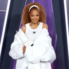 Janet Jackson wearing a curly ponytail hairstyle