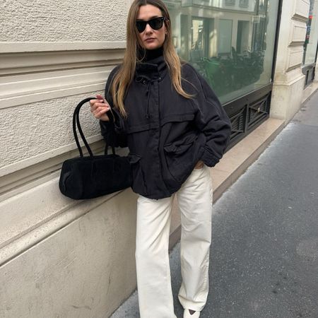 French influencer wears white jeans and white flat shoes outfit on streets of Paris