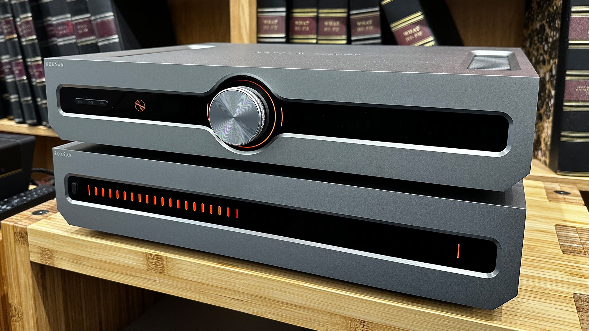 Roksan Caspian 4G Streaming Pre-Amplifier/Caspian 4G Power Amplifier on wooden hi-fi rack in front of bookcase