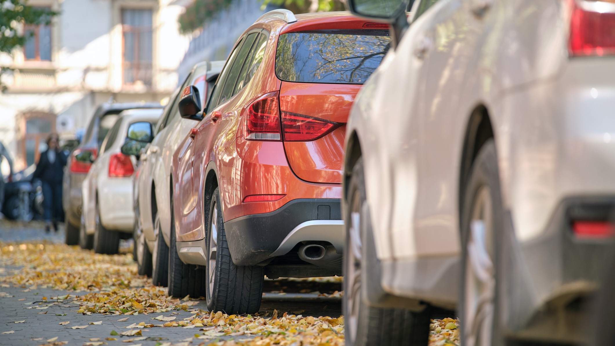 Cars lined up on a busy suburban street.