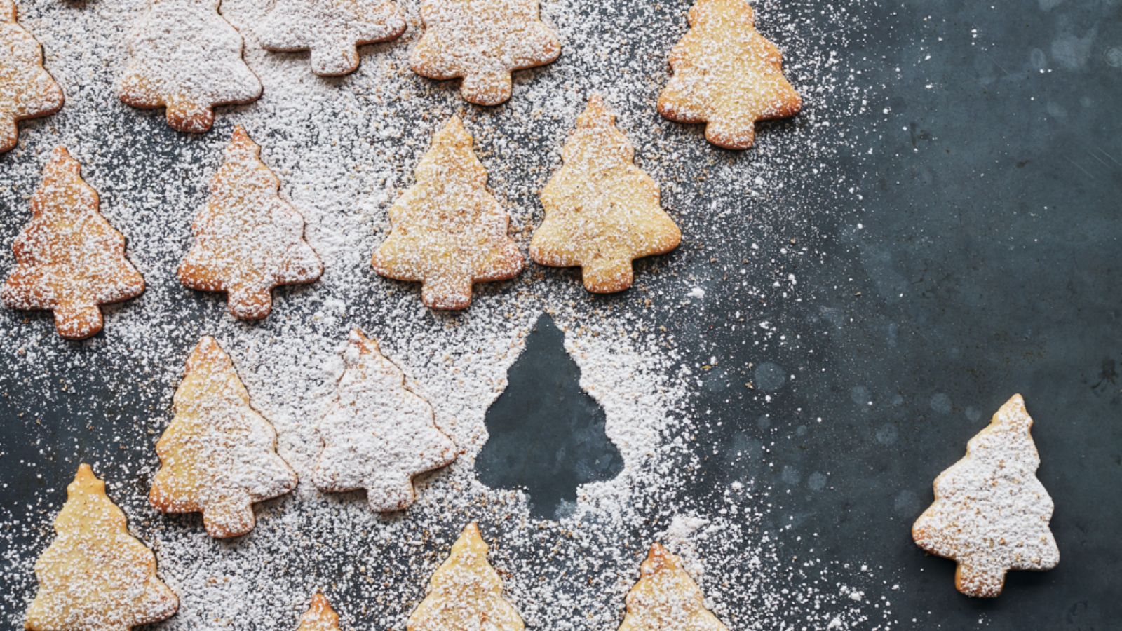 Christmas tree cookies sprinkled in icing sugar