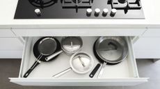 pots and pans in a drawer below the hob