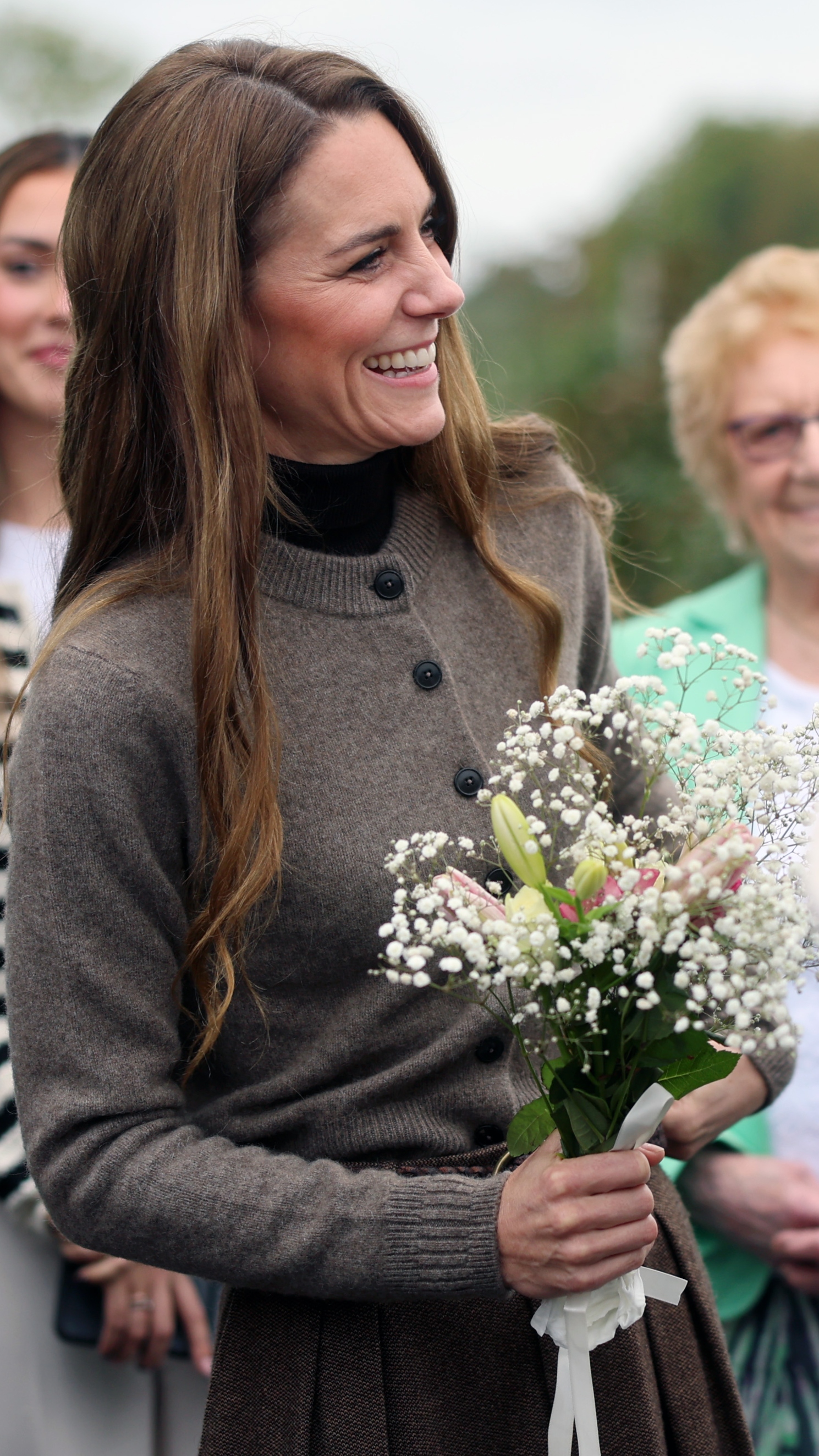 Catherine, Princess of Wales smiles and holds a bunch of flowers during a visit to Long Meadow Cider on October 14, 2025