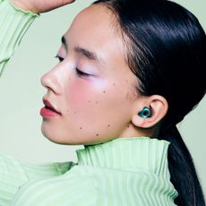 model wearing loop switch 2 earplugs in emerald