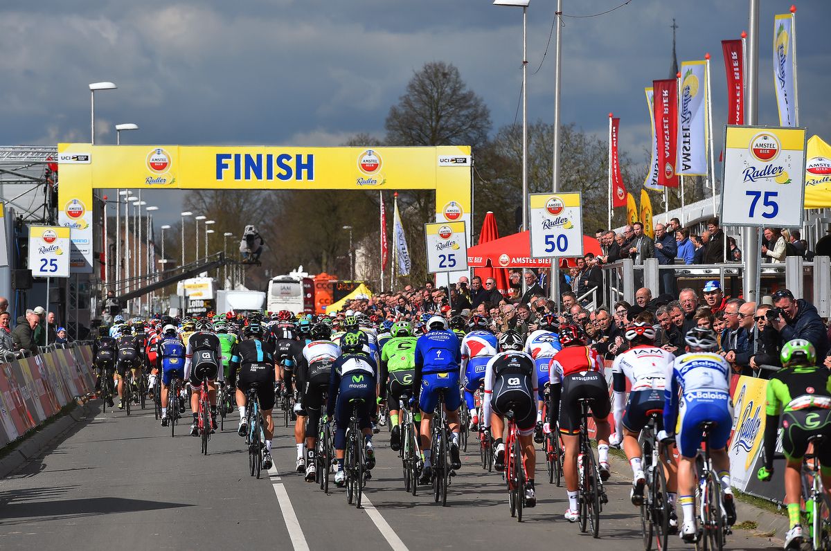 The peloton passes under the finish line