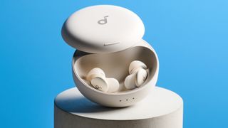 The Soundcore Sleep A30 earbuds in their case on a stone plinth against a blue background
