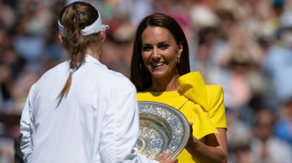 Kate Middleton in a yellow dress presenting a trophy to a tennis player