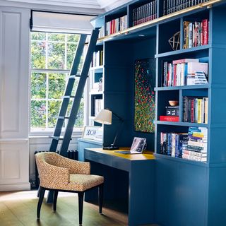blue built in desk and bookcase with patterned arm chair
