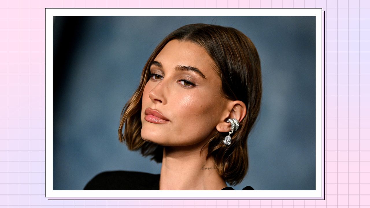 Hailey Rhode Bieber, pictured wearing black dress, with silver earrings as she attends the 2023 Vanity Fair Oscar Party Hosted By Radhika Jones at Wallis Annenberg Center for the Performing Arts on March 12, 2023 in Beverly Hills, California/ in a pink and purple template