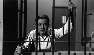 Dracula Renfield behind bars, looking for his master