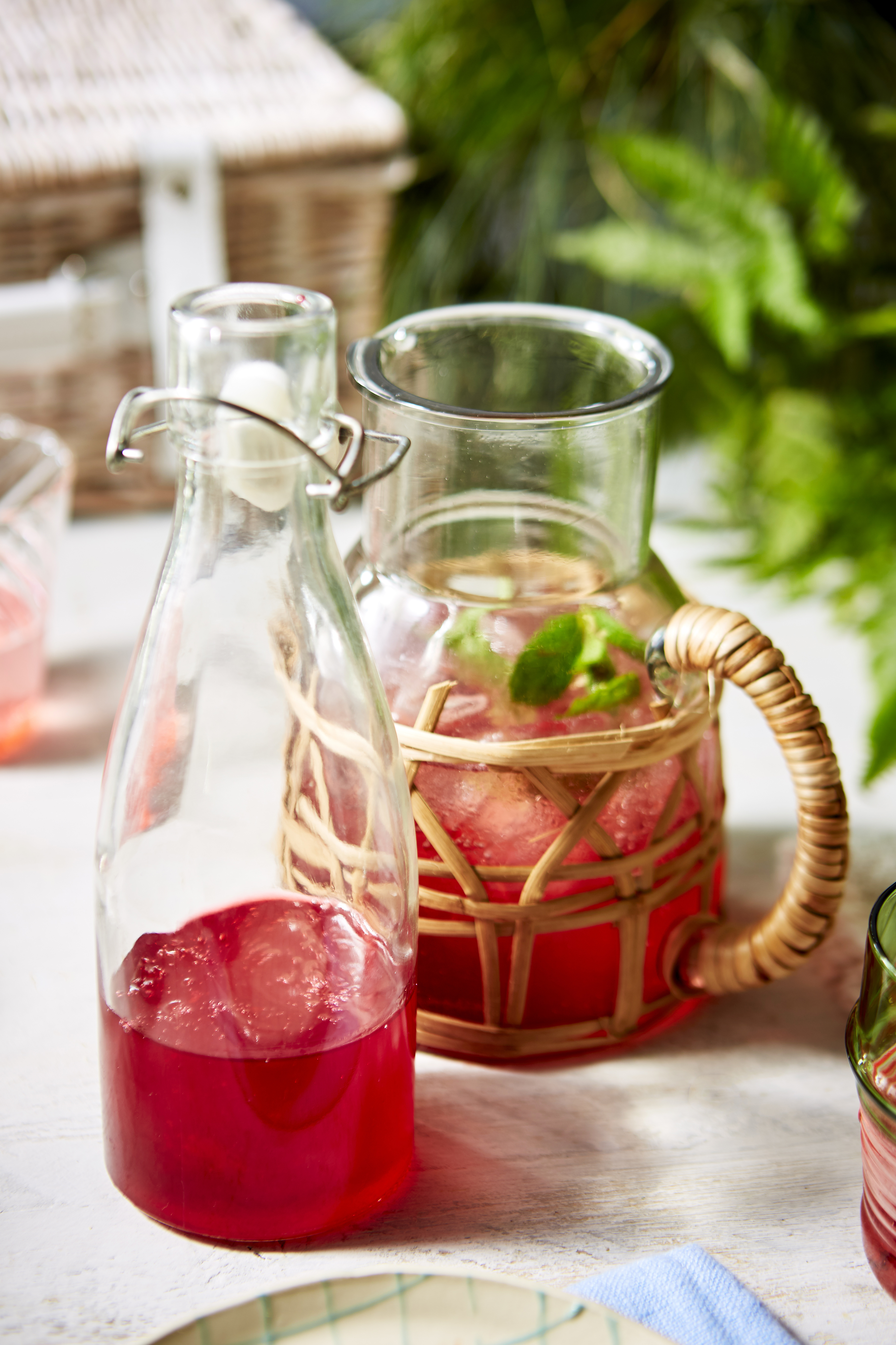 raspberry spritz pictures in a glass next to jug of the drink