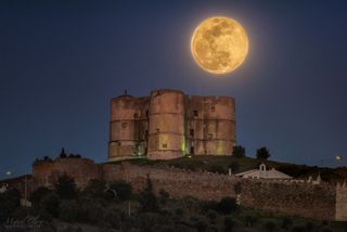 The "super worm moon" of March 21, 2019, rises over Portugal's historic Evoramonte tower.