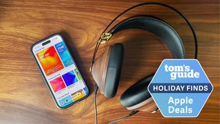 Apple Music shown on iPhone next to headphones