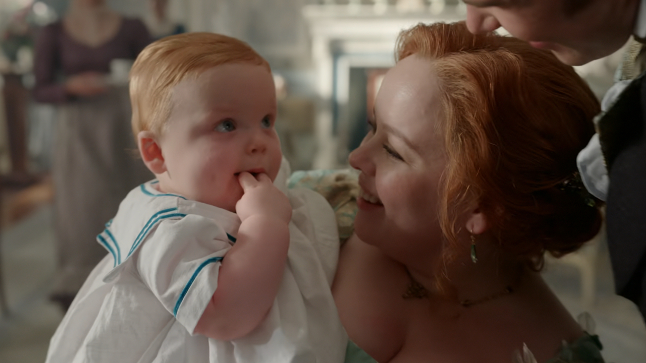 Nicola Coughlan as Penelope Bridgerton holds baby Elliot in Season 4, Episode 1 of Bridgerton.