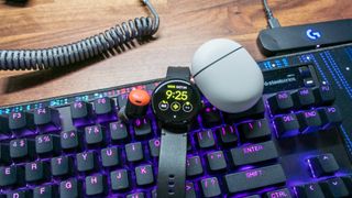 Pixel Watch with Pixel Buds Pro on top of keyboard