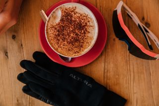 Coffee, gloves and sunglasses on a cafe table