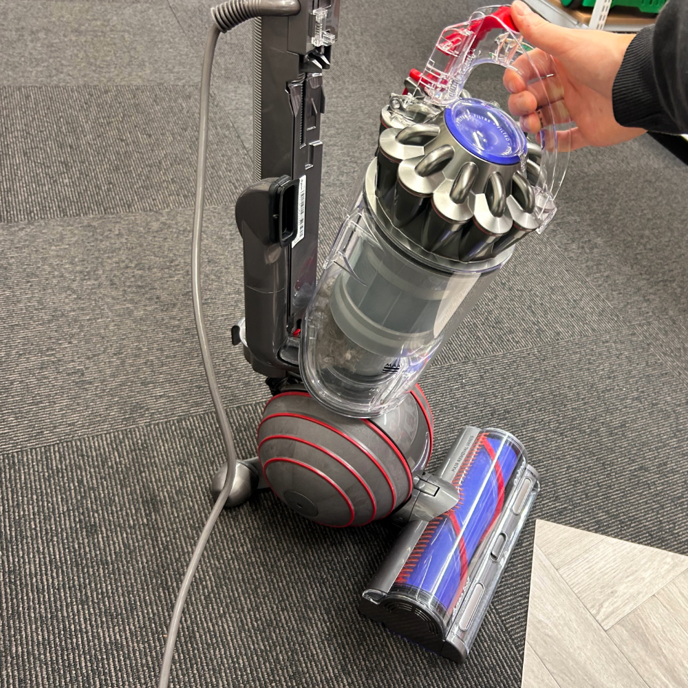 Megan's hand detaching the waste bin from the Dyson Ball Animal 3 Upright Vacuum Cleaner, one of the best vacuum cleaners for pet hair