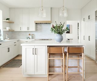 Modern white kitchen with island with wooden stools