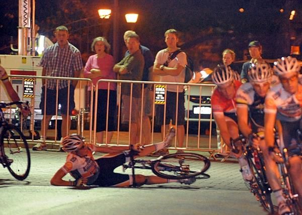Spectators gasp as a rider hits the pavement.