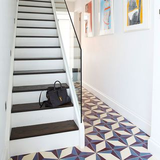 hallway with staircase and handbag with white wall and encaustic tiles