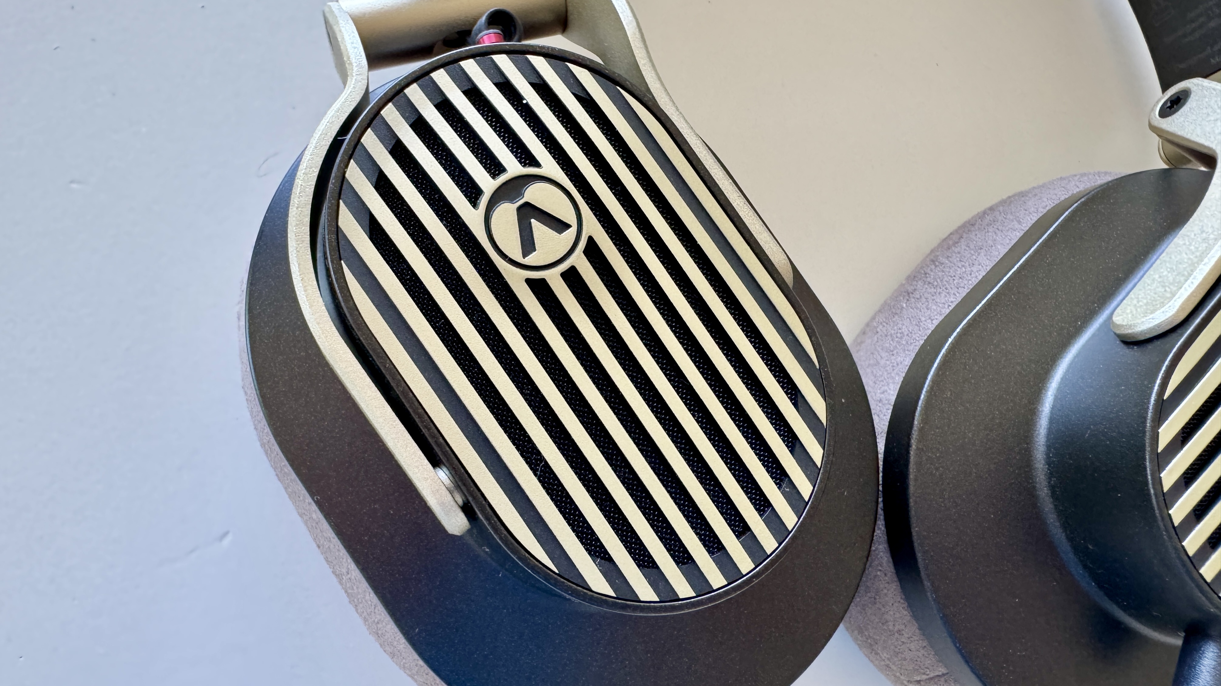 Ear cups of the Austrian Audio The Arranger open-backed over-ear wired headphones, on a white surface.