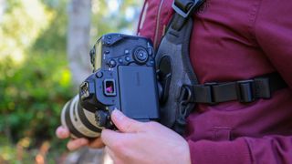 Cotton Carrier Skout G2 worn by a man in a burgandy jacket outdoors in a woods