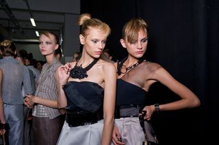 Two female models wearing black tops looking to the side