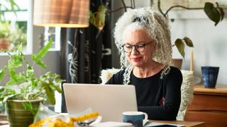 Grey haired woman working from home on her laptop