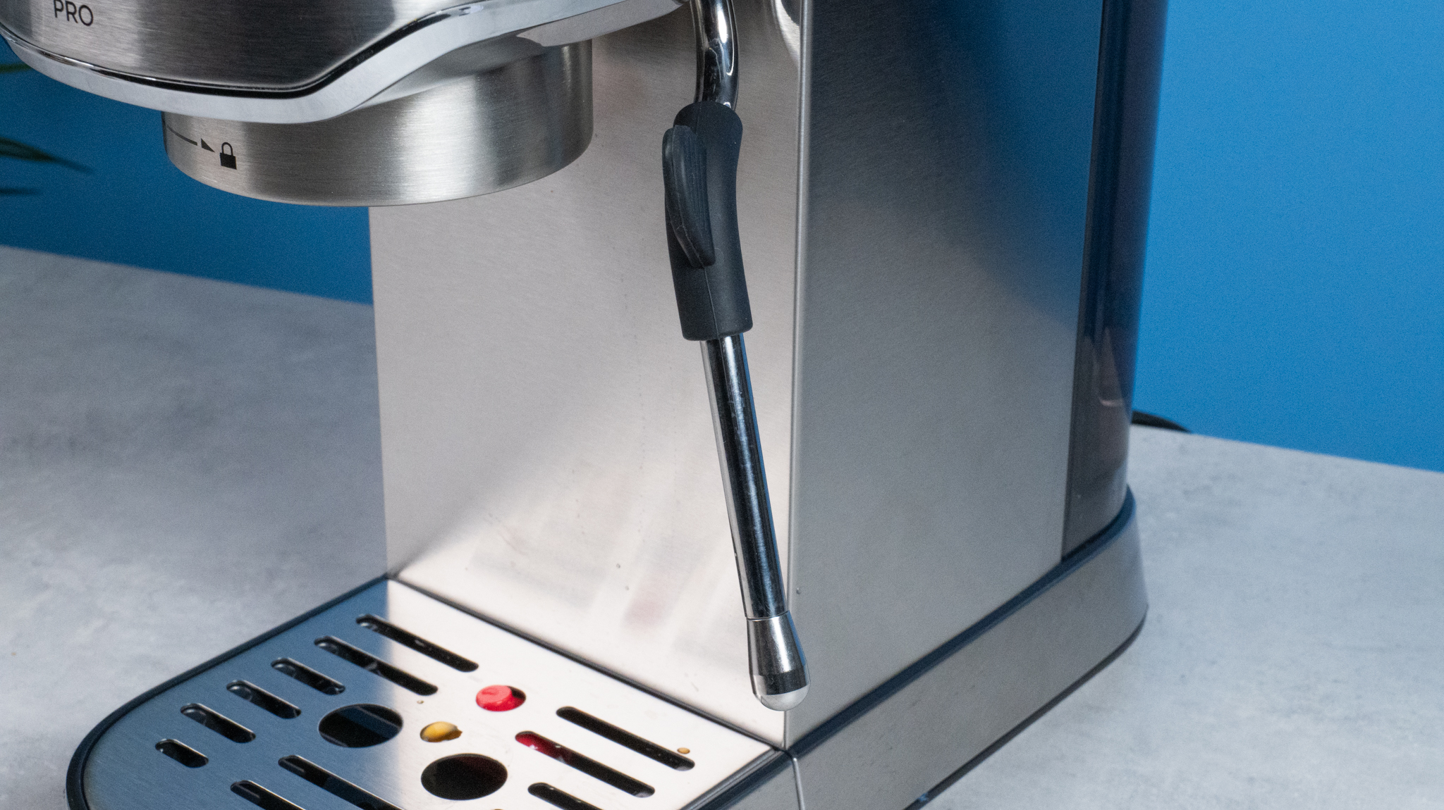 The Casabrews 5418 Pro espresso machine in stainless steel with a steam wand on the right side and three buttons on the front of the machine and a pressure gauge underneath
