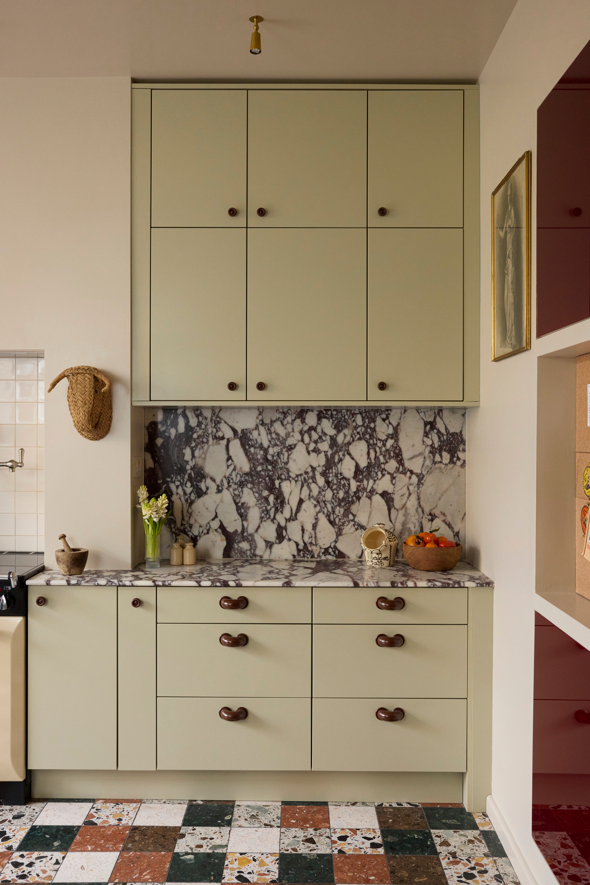 Sage green kitchen extension with patchwork tiled floor