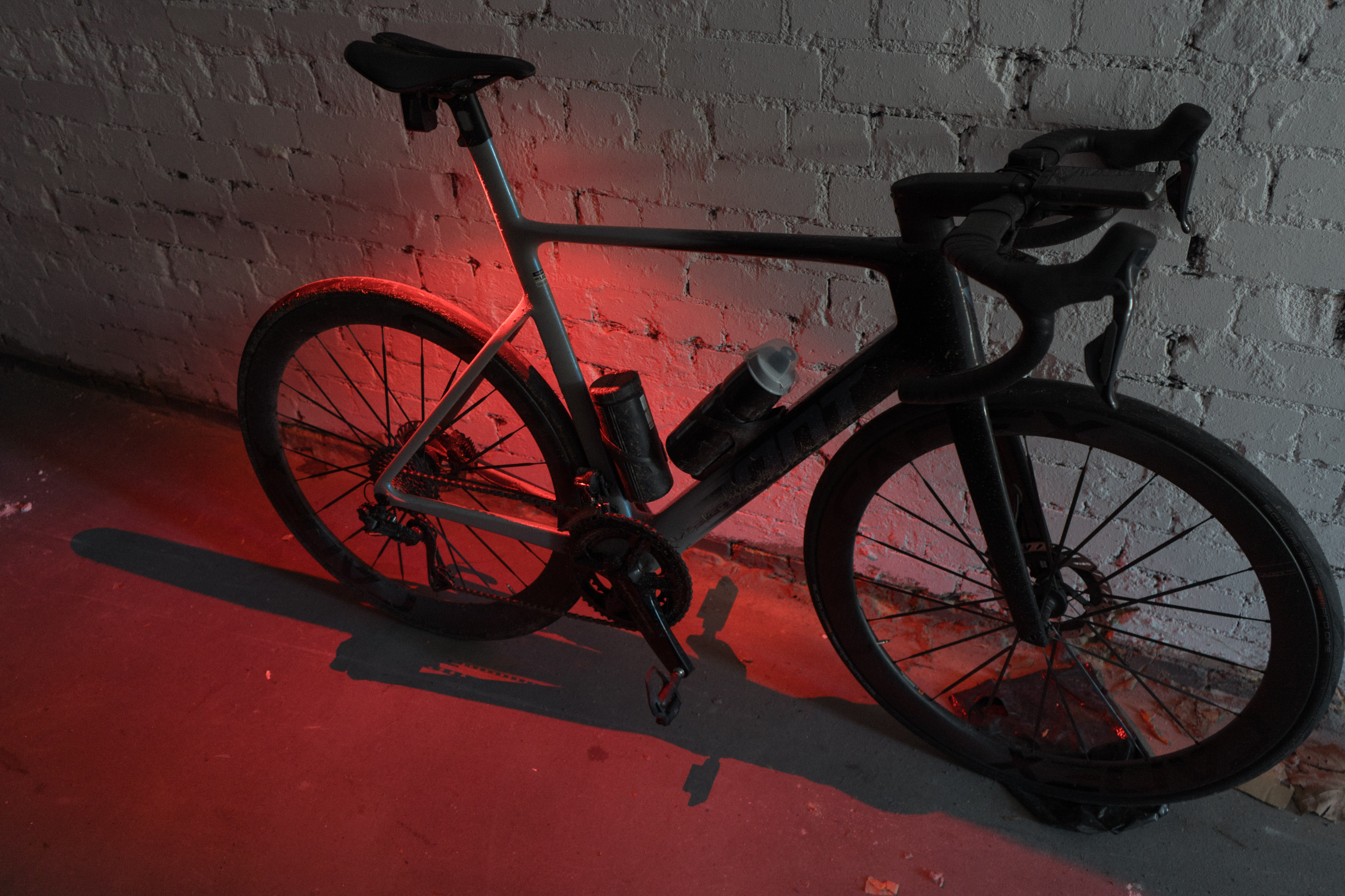 A bike with the rear and floor illuminated red around it