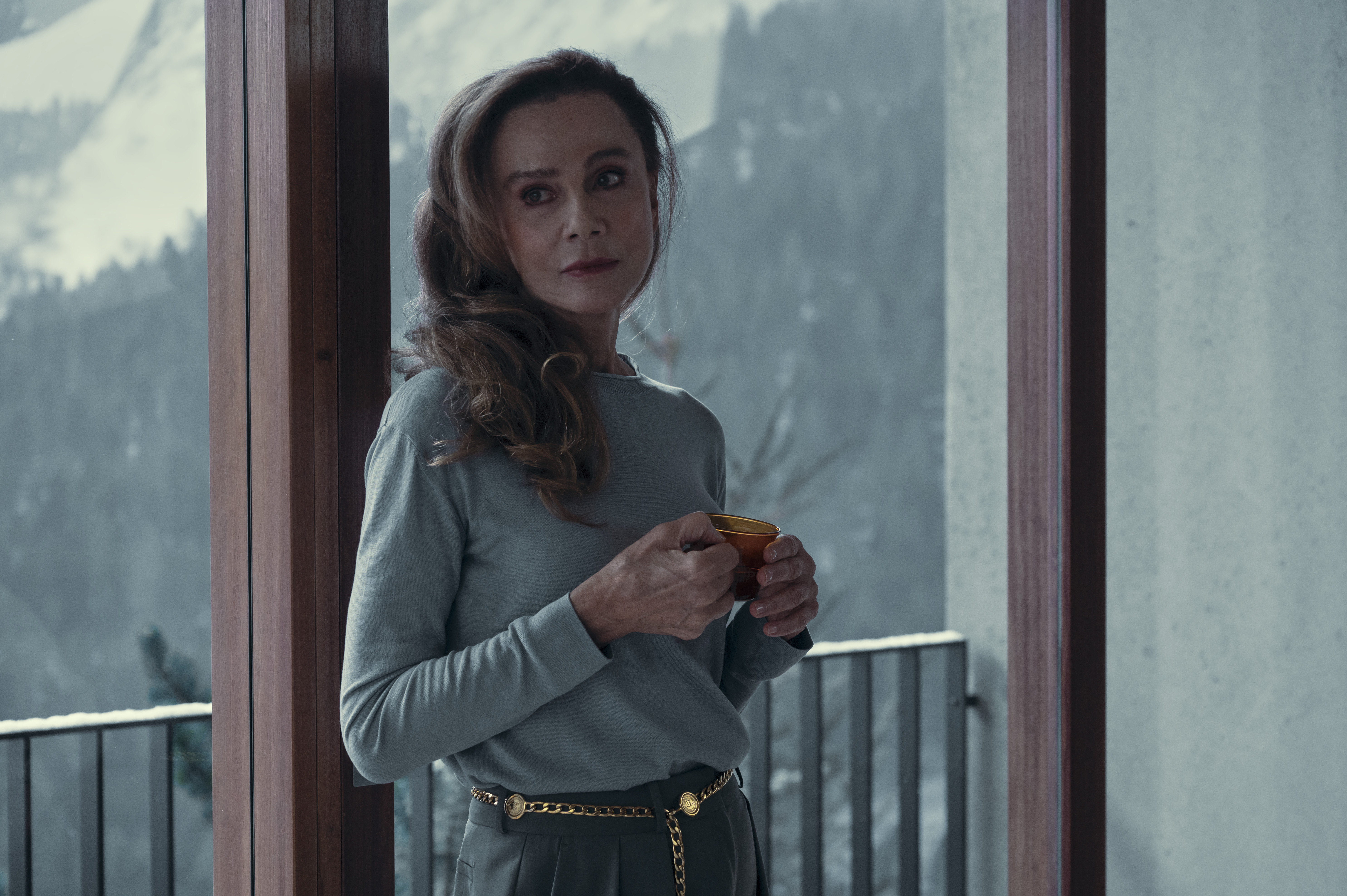 lena olin as helena standing by a window overlooking snowy alps in nine perfect strangers season 2