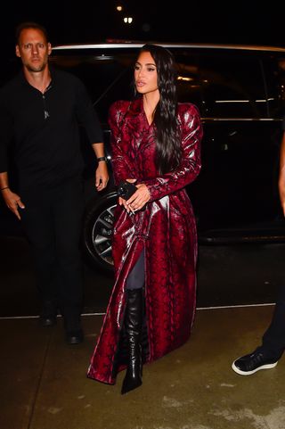 Kim Kardashian in a red leather trench coat.