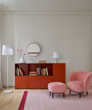living area with pink armchair and red storage cabinet
