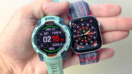 Close-up of the Garmin Instinct 3 next to the Apple Watch Series 11