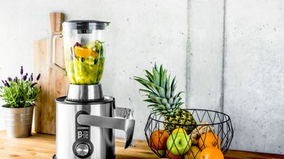 Things you should never put in a blender: A juicer with a pile of fruit beside it