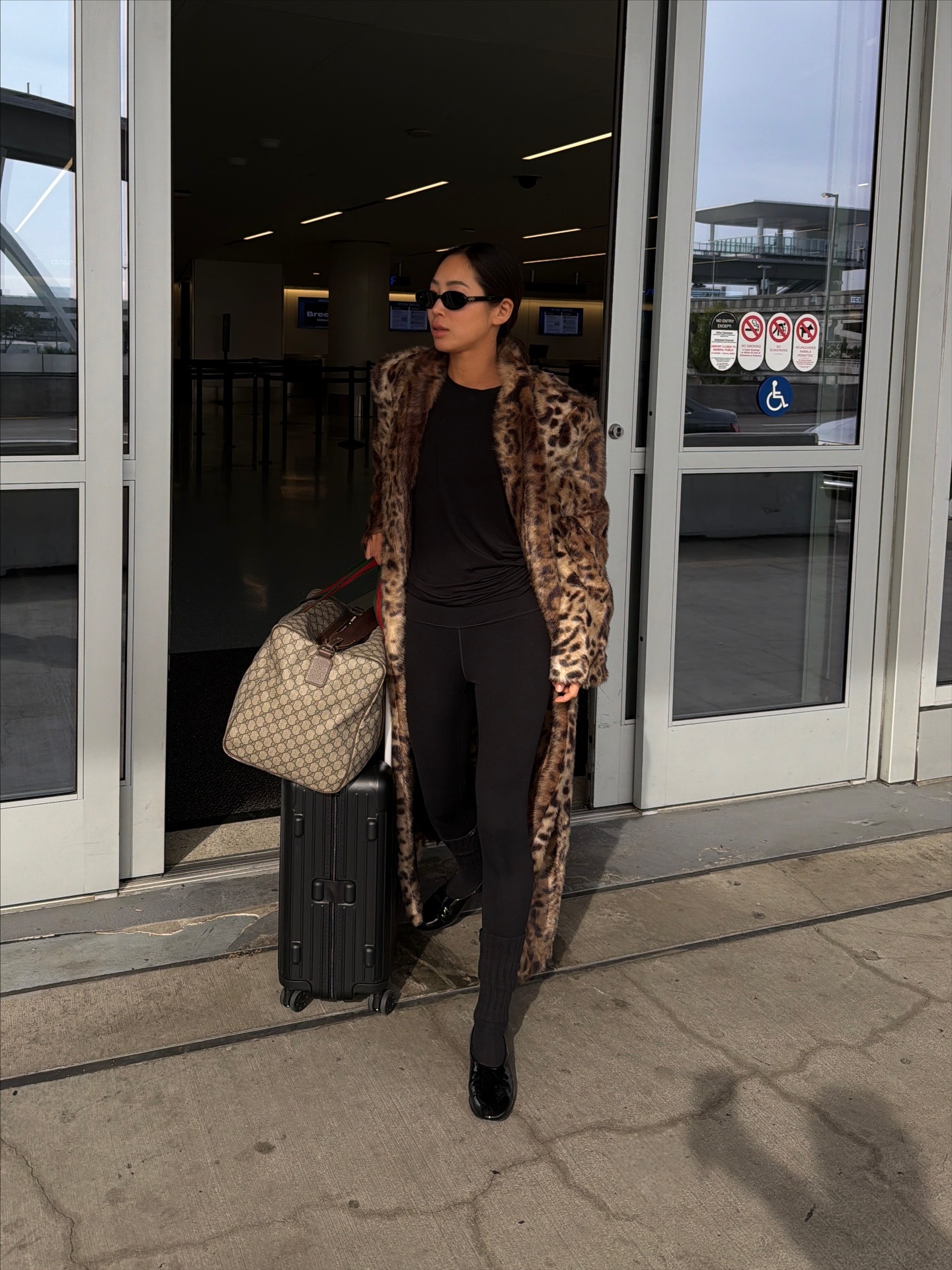 Aimee Song wearing a leopard coat, leggings, and flats.