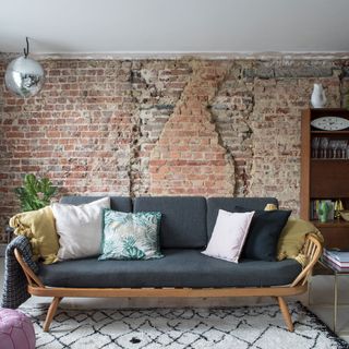 living space with brick wall and pillows on sofa