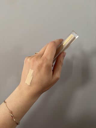 Mica Ricketts showing swatch of Hourglass Vanish Airbrush Concealer