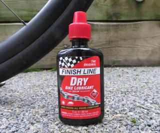 Bottle of Finish Line Dry Lube by a bike