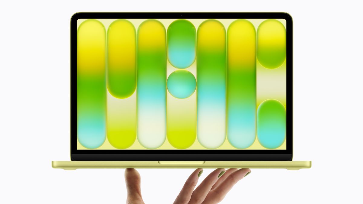 Apple MacBook Neo in yellow on a person's fingers