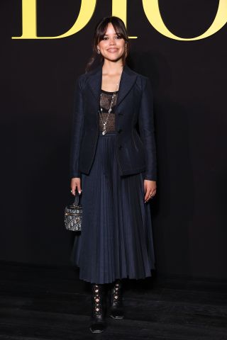 Jenna Ortega in a denim blazer and maxi skirt with sheer top at the Christian Dior Womenswear show in Paris, France.