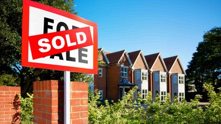 Photo of a sold sign in front of houses